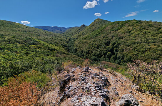 Rocky viewpoint overlooking the deep forested valley of the Baroc Stream and the Dedes Castle hills near Malyinka in the Bukk Mountains, Hungary.