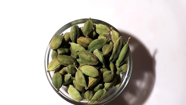 Cardamom in glass bowl table top view spin.