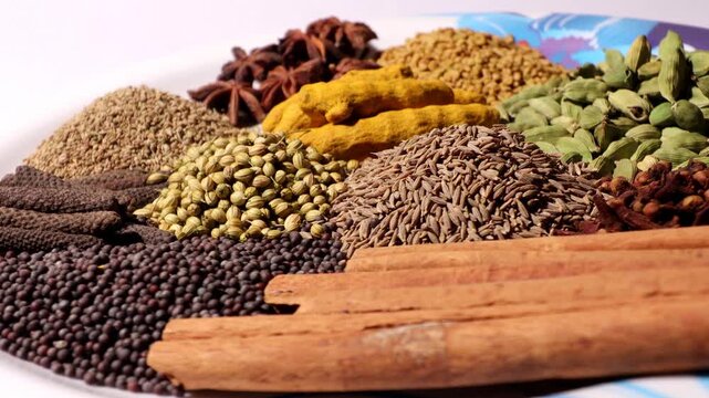 Set of dried Indian spices in serving plate table top view spin.