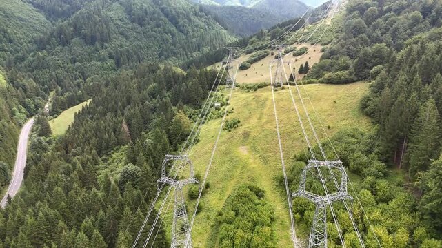 Aerial view of high-voltage power lines cutting through the forested Korytnicka dolina valley in Liptovska Osada, Zilinsky kraj, Slovakia.