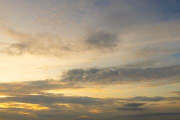 Fototapeta premium Beautiful Golden Hour Sunset Sky with Soft Clouds,A serene and peaceful view of the evening sky during sunset, featuring warm golden light illuminating soft clouds and a gentle gradient of blue.
