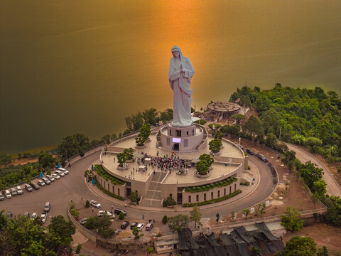 Aerial view of Our Lady of Nui Cui statue overlooking Tri An Lake in Dong Nai, Vietnam, at sunset.