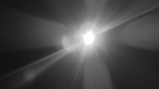 abstract photo of light burst among trees and glitter bokeh. image is blurred. yellow golden bokeh pattern background. Real optical lens flare on black backdrop. sunrays, sun rays beam, burst, sunbeam