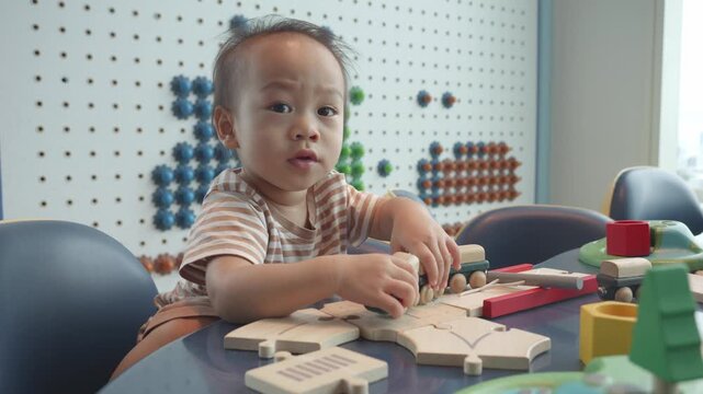 A young child focused on assembling a wooden puzzle in a vibrant play area, surrounded by various colorful toys. The scene captures moments of curiosity and playfulness, highlighting the benefits of h