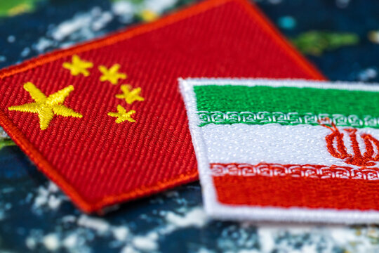 Business concept close-up of China and Iran flag patches symbolizing strategic economic alliance
