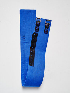 Blue arming belt with dual buckles and black adjustment strap laid flat on white surface.