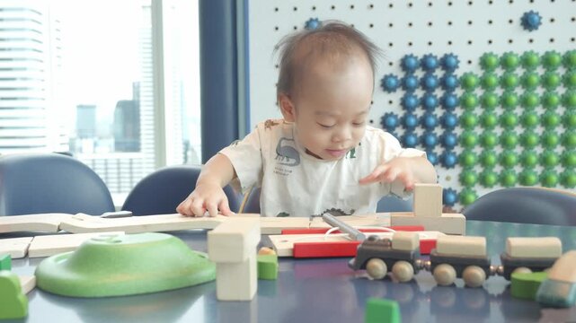 A young child explores creativity and learning by playing with colorful wooden toys and blocks in a bright environment. This playful scene emphasizes the importance of early childhood development thro