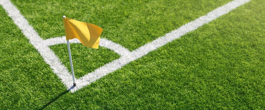 Yellow corner flag on green grass soccer field with white boundary lines