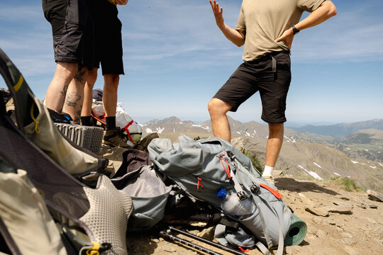 Anonymous men talking with hiking gear on Pyrenees summit