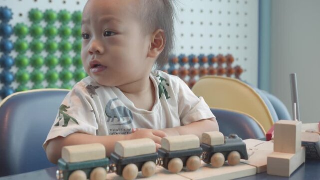 A curious child explores a wooden train set, surrounded by vibrant colors. The playful scene captures the joy of childhood and imaginative play, highlighting the importance of creative toys.