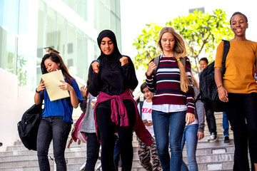 Fototapeta premium Diverse students walking campus stairs.