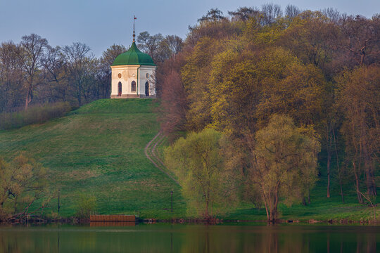Beautiful scenic landscape of an old antique gazebo on a green hill by the lake