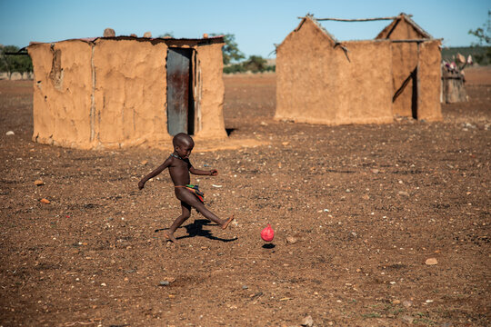 Himba child playing football in Namibia village