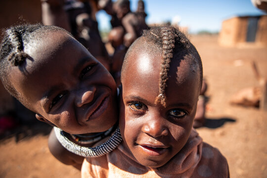 Himba children smiling and looking at camera in Namibia