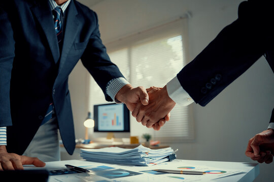 Businessmen shaking hands making agreement in office