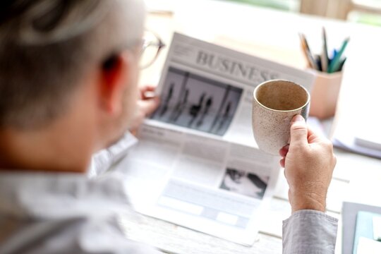 Man reading business newspaper calmly