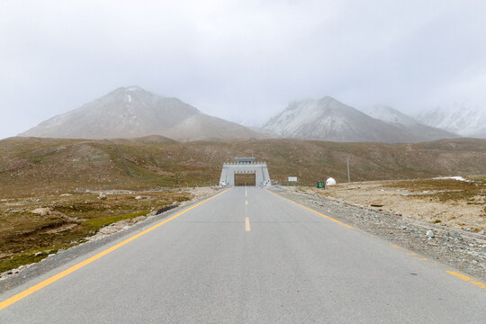 View of the Khunjerab Check Post at the Pakistan-China border on the Karakoram Highway, featuring a gate structure against rugged, snow-dusted mountains in Hunza Nagar, Gilgit Baltistan, Pakistan.