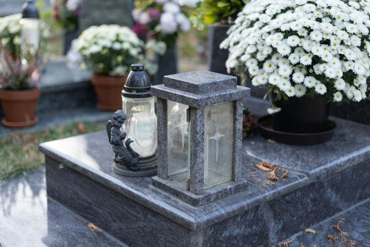 tombstone with memorial candle and chrysanthemum in the cemetery