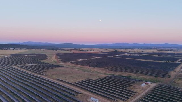 Aerial view of a large solar farm with rows of photovoltaic panels at sunset in the rural landscape of Ciudad Rodrigo, Castile and Leon, Spain.