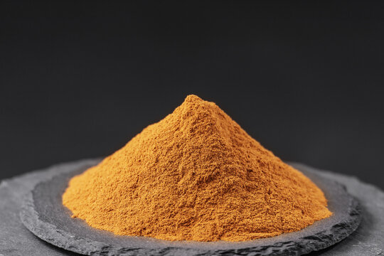 cinnamon powder from chinese cassia tree on a black slate stone tray