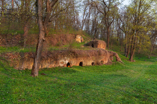 Beautiful scenic view of antique brick ruins on a hill in a spring forest at sunset