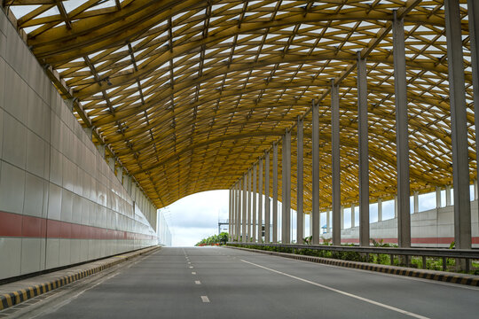 View of the Karnaphuli Tunnel entrance featuring a distinctive yellow lattice roof structure and modern concrete walls in Anowara, Chittagong Division, Bangladesh.