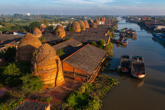 Aerial panoramic view of Mang Thit pottery village with traditional red brick kilns along the river in Vinh Long, Vietnam.
