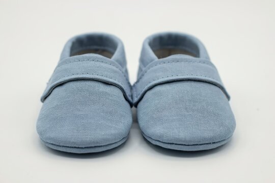 Pair of light blue baby shoes isolated on white background
