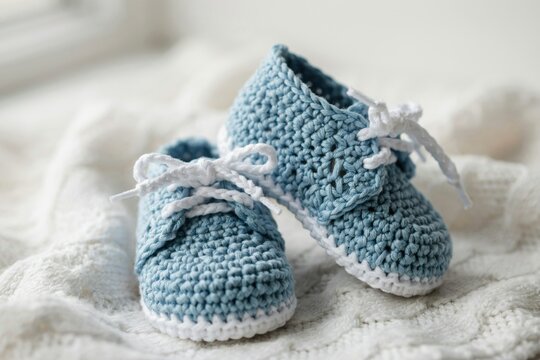 Pair of handmade blue crochet baby booties with white laces