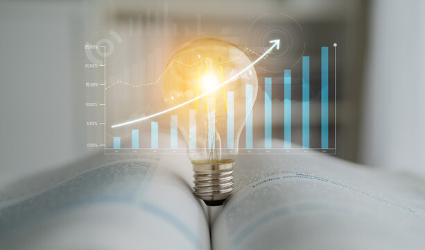 A light bulb rests on an open book, symbolizing innovative ideas and knowledge while financial graphs indicate growth and potential in business development. Scalp