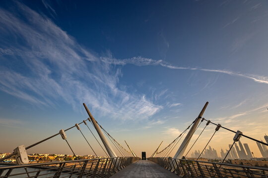 View of the Tolerance Bridge with its distinctive cable-stayed design and the modern Dubai skyline in the background under a clear blue sky in Dubai, Dubai, United Arab Emirates.