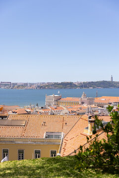 wide landscape shot of Lisbon, Portugal with orange tiled roofs looking towards Tagus River on a sunny clear day