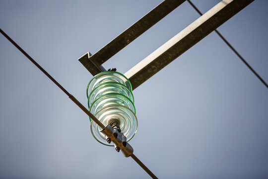 Close-up of a glass insulator on a high-voltage transmission tower