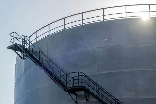 View of a large industrial storage silo with an external metal staircase under a bright sky in Lisboa, Portugal.