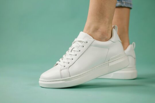 Woman wearing stylish white leather sneakers