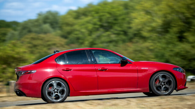 Milton Keynes; UK - Aug 23rd 2026:;  2026 red Alfa Romeo Giulia Veloce tb car driving on a British road