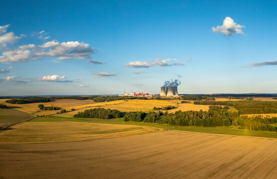 cooling towers of the Temelin nuclear power plant surrounded by rural summer landscape with fields and forests Czech republic