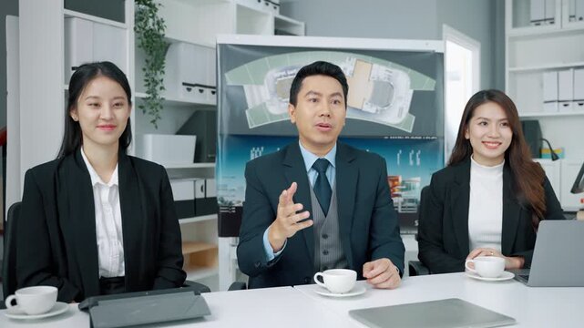 Professional business team discussing an architecture and construction project during a meeting in a modern office. Male manager presenting ideas while two female colleagues listen with documents and 