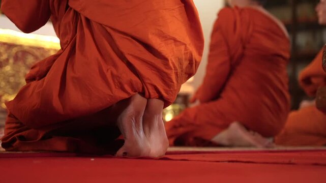 Bare feet Buddhist Monks Praying to Buddha from Behind in Luang Prabang, Laos. Traditional Buddhist Maroon Monastic robe