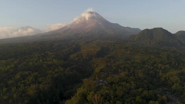 Aerial view of merapi volcano with lush forest and clouds in Kecamatan Turi, Daerah Istimewa Yogya, Indonesia.