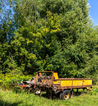 Verrosteter landwirtschaftlicher Einachsh&auml;nger mit historischem Stalldungstreuer auf einer Wiese, Uckermark, Brandenburg, Deutschland