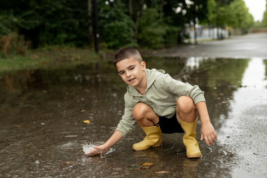 Child Playing in a Puddle Outdoors