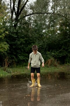 Child Playing in a Puddle Outdoors