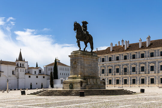 View of the Ducal Palace of Vila Vicosa with the equestrian statue of King John IV in the foreground, set in a historic square with white buildings in Vila Vicosa, Distrito de Evora, Portugal.