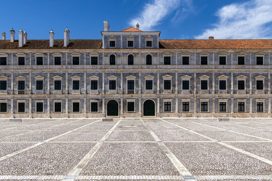 View of the Ducal Palace of Vila Vicosa with its symmetrical marble facade, ornate windows, and tiled roof under a clear blue sky in Vila Vicosa, Distrito de Evora, Portugal.