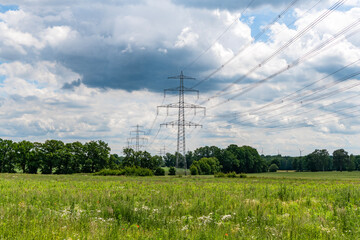 Naklejka premium Electricity power lines in nature landscape. Green nature energy. Landscape of electric voltage station. High voltage. Electricity pylon. Nature summer environment. Electricity tower