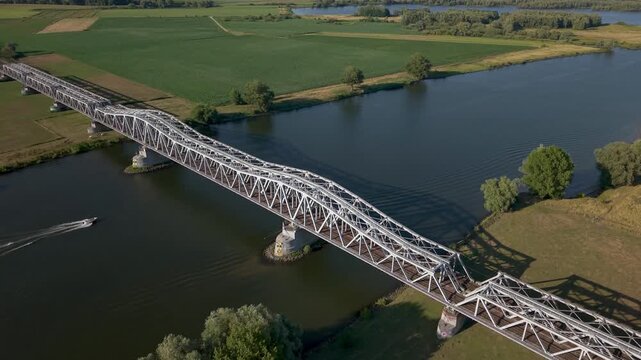 Aerial view of Hedelse Spoorbrug railway bridge spanning the Meuse river between Den Bosch and Hedel in North Brabant, Netherlands.