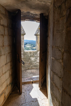 View of an open stone doorway in a historic castle tower looking out over the rolling landscape of Estremoz, Evora District, Portugal.