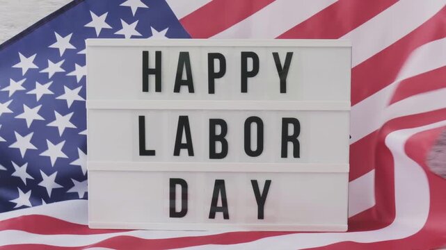 Light box with Happy Labor Day text placed in front of an American flag for patriotic holiday