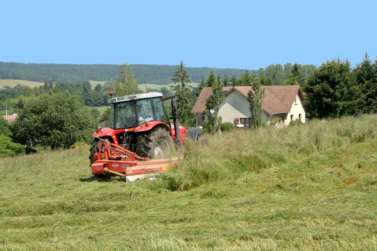 Agriculteur  en plein travail de moisson avec son tracteur  Massey Fergusson